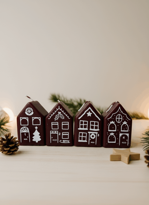 Set van vier rode advent kerstkaarsjes in de vorm van huisjes, gepresenteerd in Scandinavische stijl met natuurlijke kerstdecoratie.